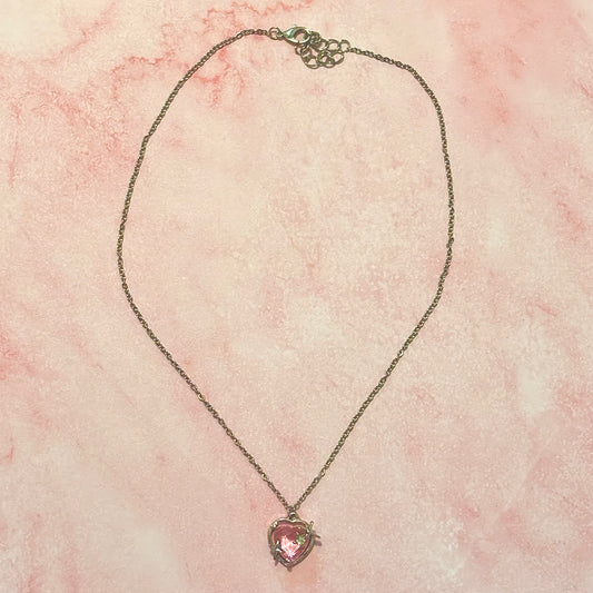 Flat lay of Starlit Love Necklace with heart pendant and silver chain