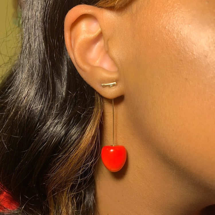 Close-up of model wearing vibrant red Sweet Cherry Earrings
