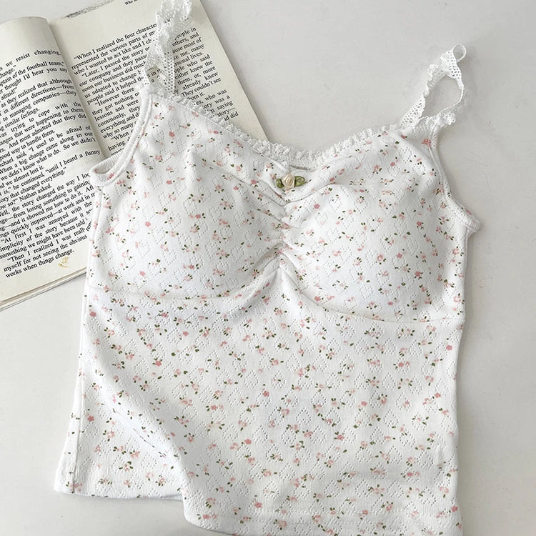 Flatlay of Sweet Flower Crop Top in white with tiny pink floral pattern, laid next to an open book.