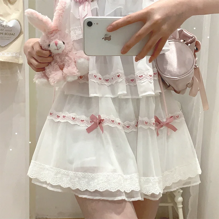 Close-up of the white and pink Sweet Love Lace Bow Skort, highlighting the heart lace trim, layered mesh, and pink bow accents.