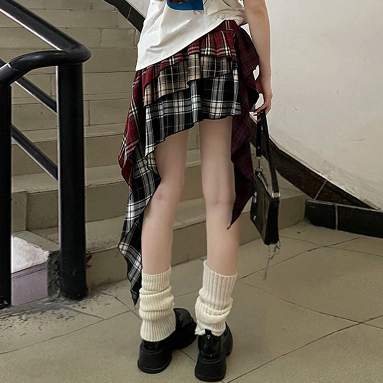 Model wearing the Tilted Temper Tartan Skirt standing, showing the back of the skirt