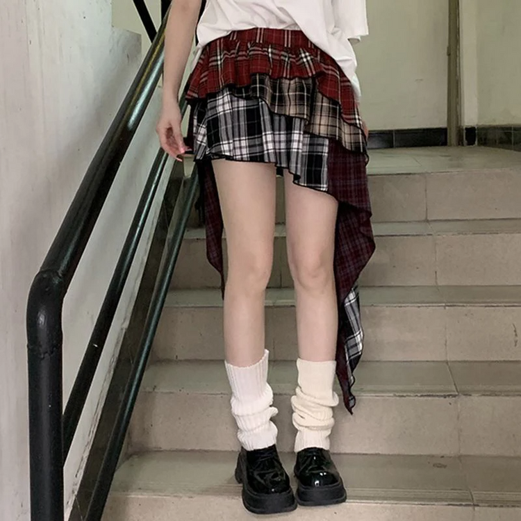 Model wearing the Tilted Temper Tartan Skirt standing straight, showing asymmetrical layers