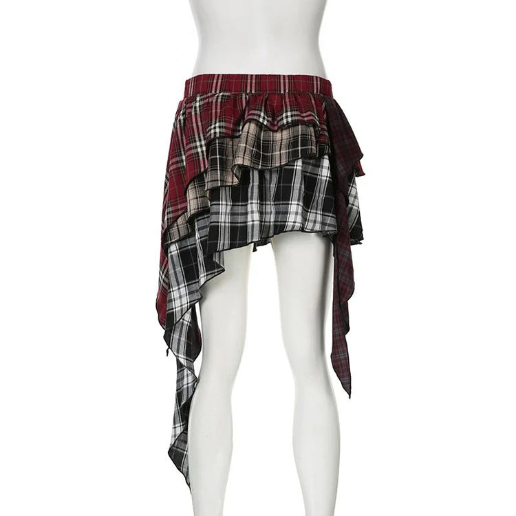 The back of the Tilted Temper Tartan Skirt on a white mannequin, showcasing mismatched plaid panels and angled hem