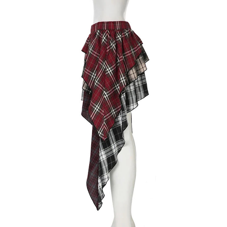 The Tilted Temper Tartan Skirt on a white mannequin at a side angle, showcasing mismatched plaid panels and angled hem
