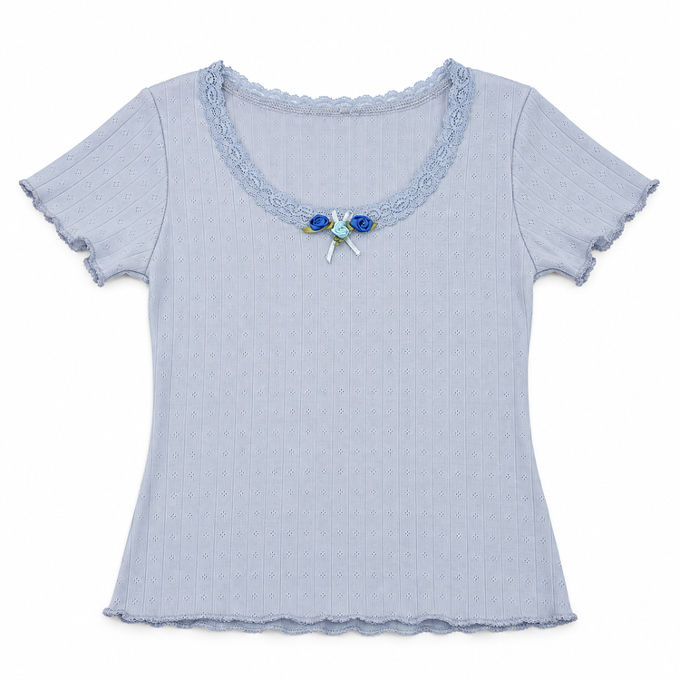 Front flat lay of the blue Two Moody Originals: Floral Daydream Top with pointelle texture, scalloped lace, and three blue rose appliqués with a bow.