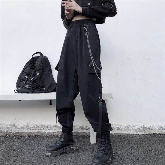 Angled view of model wearing black Chain Reaction Cargo Joggers with metal chain attached
