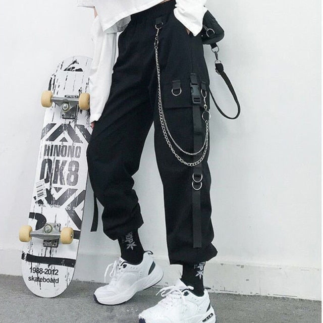 Side view of model posing with hand in pocket wearing black Chain Reaction Cargo Joggers with metal chain attached