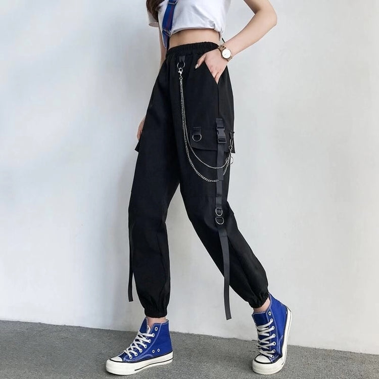 Side angle of model walking and wearing black Chain Reaction Cargo Joggers showing flap pocket and hanging chain