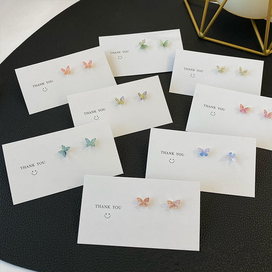 All color options of the Dreamlit Butterfly Stud Earrings shown individually on cards