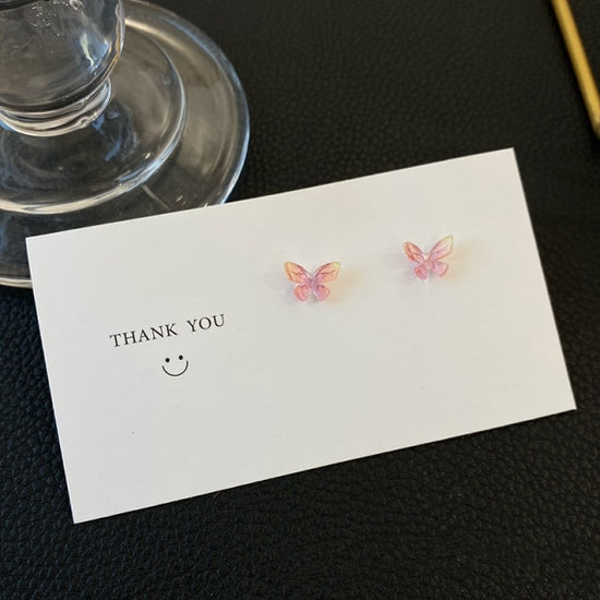 Dreamlit Butterfly Stud Earrings in a soft pink and yellow blend on a thank-you card.