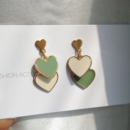 Olive You Triple Heart Earrings shown front-facing on display card, featuring three stacked hearts in olive green and ivory with gold-tone edges.