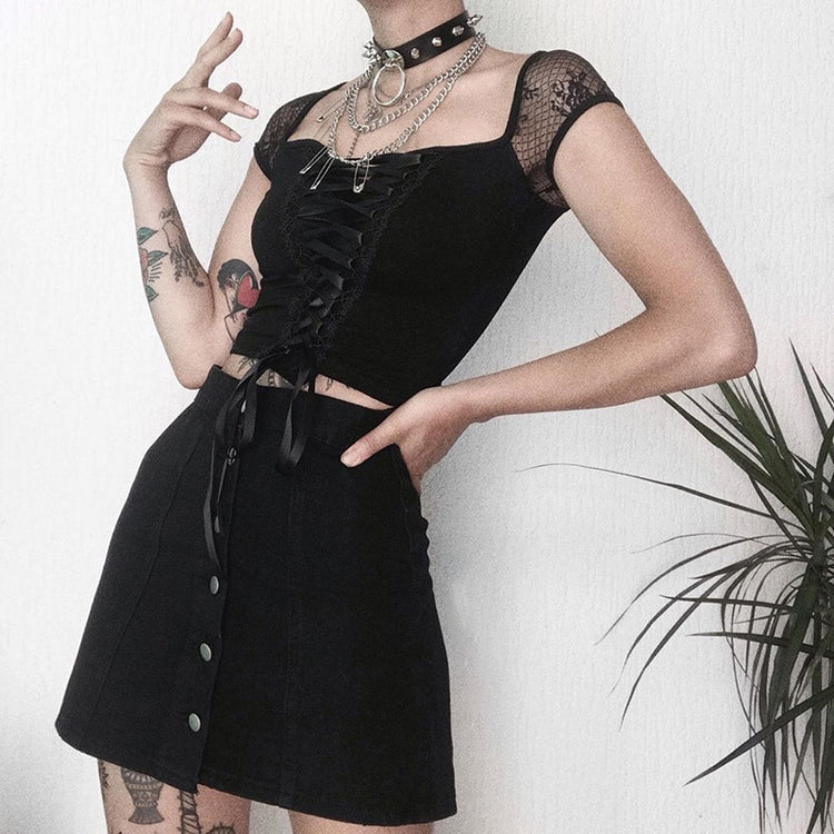 Confident pose of model in Petal Noir Top with hands on hips and full styling visible