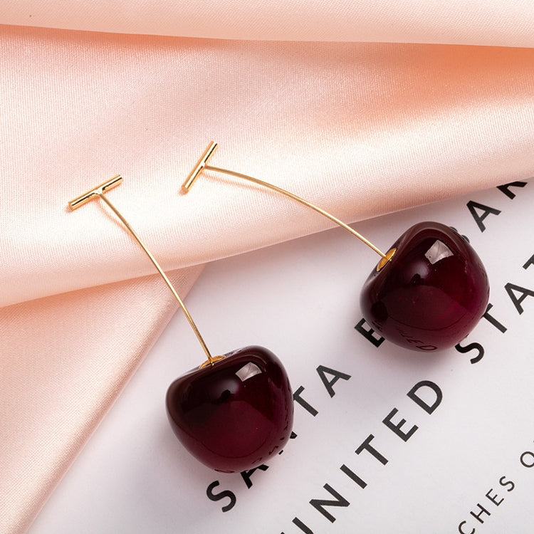 Sweet Cherry Earrings in dark red styled next to decorative props