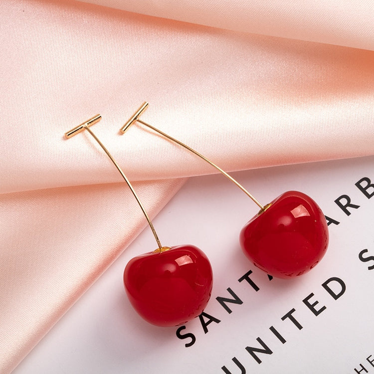 Sweet Cherry Earrings in red styled next to decorative props
