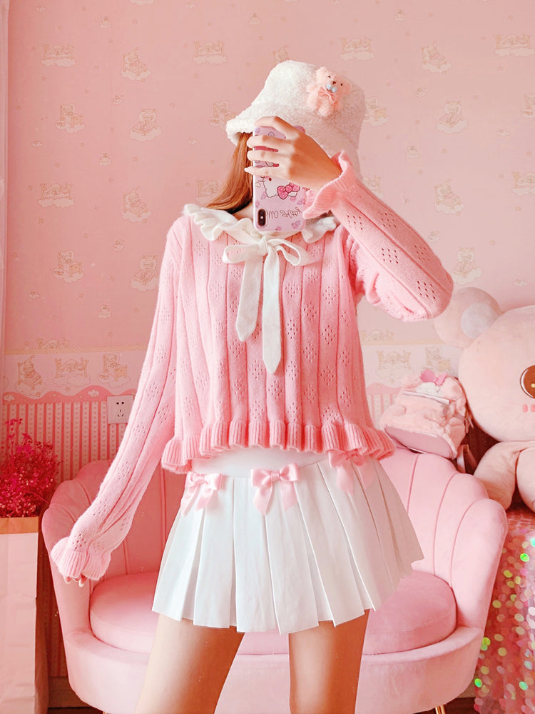 Full outfit with the Sweetheart Academy Skort, a cozy pink sweater, and a fuzzy white bucket hat in a pink bedroom setting
