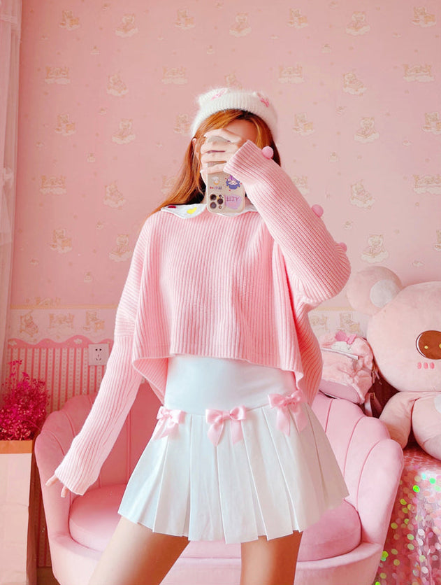 Full outfit with the Sweetheart Academy Skort, a cropped pink sweater, and a fuzzy white beanie in a pink bedroom setting