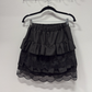 The Frosted Layers Ruffle Skort in black on a hanger.