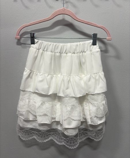 The Frosted Layers Ruffle Skort in white on a hanger.