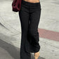 Front view of model wearing Y2K Business Chic Trousers with low-rise fit and vertical stripes, styled with a crop top and heels.