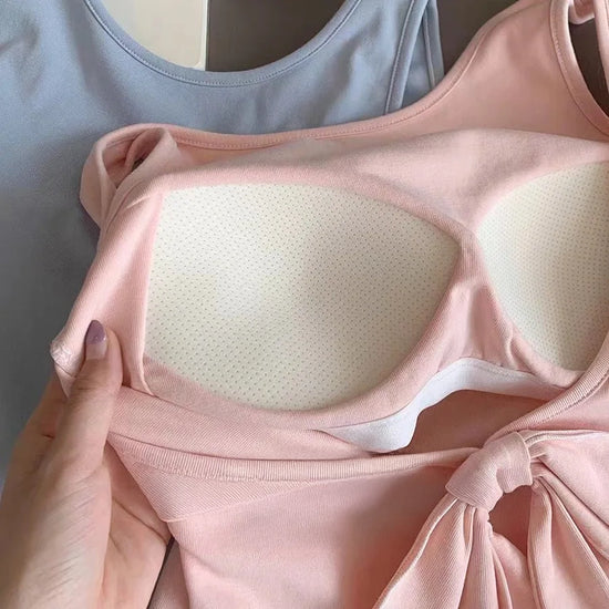 Close-up of the pink Backstage Bow Backless Tank, highlighting the open back and built-in bra, with the front of the blue version in the back.