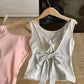 Back view of the gray Backstage Bow Backless Tank, featuring an oversized bow detail, next to the front view of the pink version.