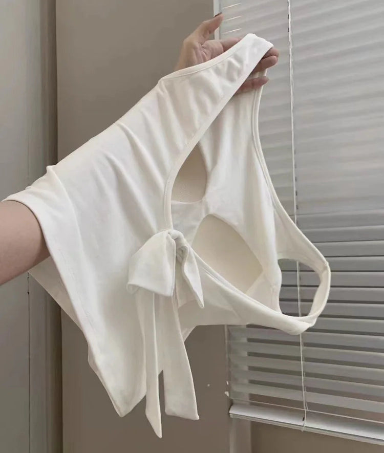 Hanging side view of the white Backstage Bow Backless Tank, highlighting the built-in bra and open back.