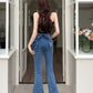 Model in a doorway showcasing the back view of the Dark Blue Backstage Bow Flare Jeans.