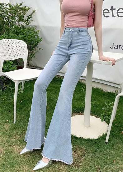 Model leaning on a table in the light Blue Backstage Bow Flare Jeans.