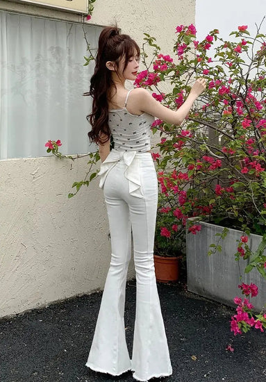 Angled back view of the white Backstage Bow Flare Jeans, highlighting the bow.