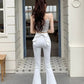 Outdoor photo of a model in the white Backstage Bow Flare Jeans with soft natural lighting.