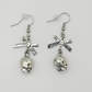 Side profile of the Bad to the Bow Earrings, featuring silver-plated skull charms with bow accent