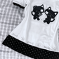 Close-up view of the Bandaged Kitties Off-Shoulder Top, highlighting the bandaged kitty graphic, contrasting polka dot trim, and decorative paw print and bone accents along the hem.