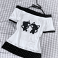 Flat lay of the Bandaged Kitties Off-Shoulder Top showcasing the adjustable halter strap, off-shoulder neckline, bandaged kitty graphic, contrasting polka dot trim, and decorative paw print and bone accents along the hem.