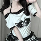 Close-up of the model wearing the Bandaged Kitties Off-Shoulder Top highlighting the off-shoulder neckline, adjustable halter strap, contrasting polka dot trim, and bandaged kitty graphic.