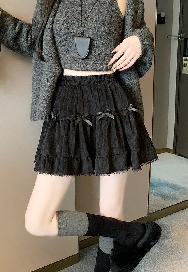 Detail shot of a model posing in the Bow Peep Mini Skort in Black, emphasizing the fit and bows.