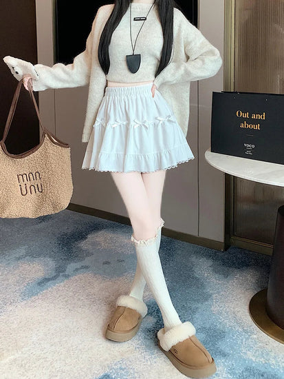 Front view of model posing in the Bow Peep Mini Skort in White with pleats and bow details.