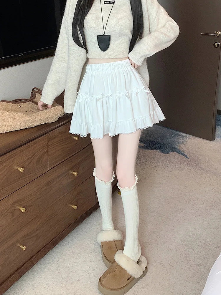 Front view of a model standing in a bedroom in the Bow Peep Mini Skort in White.