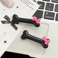 Pair of black Bowtiful Bones Hair Clips, featuring glossy bone-shaped designs with pink bow accents.