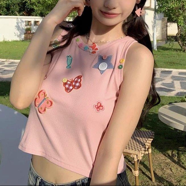 Front outdoor view of a model wearing the dusty pink Charm Collector Tank with denim bottoms.