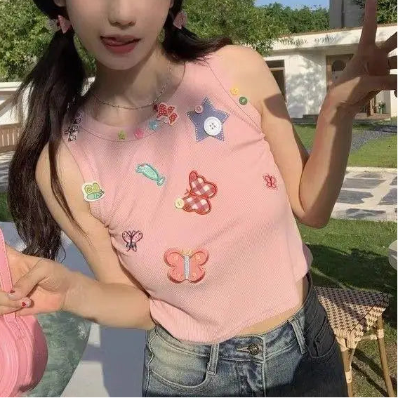 Model wearing the dusty pink Charm Collector Tank and making a peace sign outdoors.