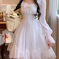 Model wearing the Cloudlight Fairy Dress while holding a bouquet of white and pink roses, front view