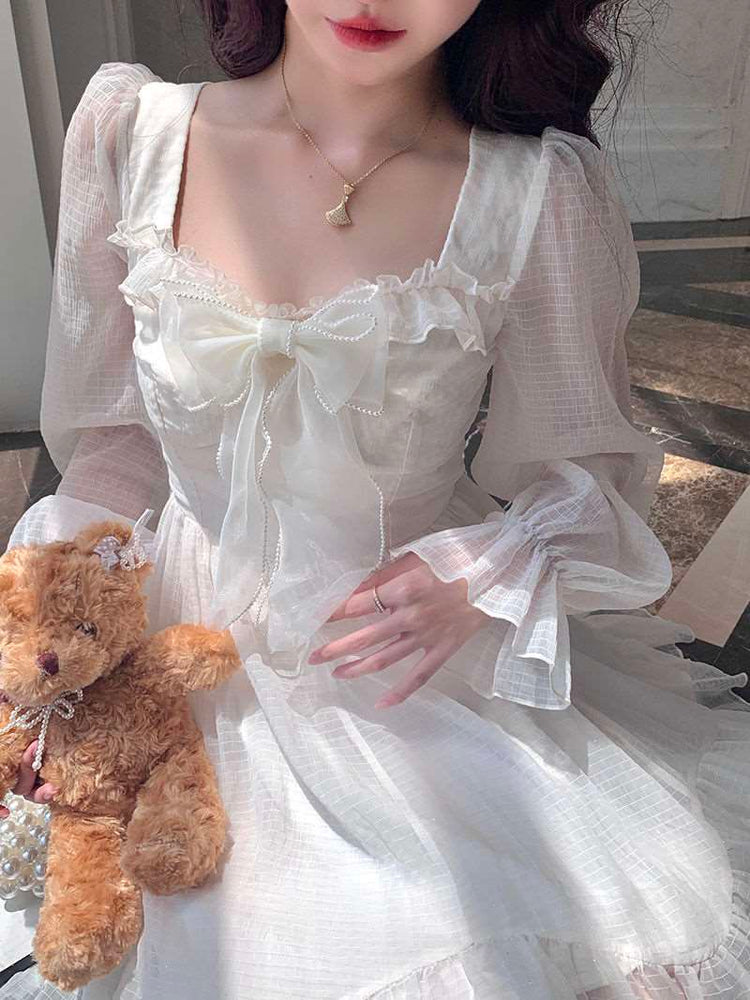 Model sitting in the Cloudlight Fairy Dress while holding a soft, brown teddy bear