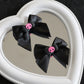 Creep It Cute Hair Bows — Pair of black skull hair bows displayed together on a heart mirror.