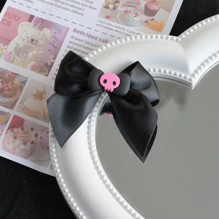Creep It Cute Hair Bows — Single black satin hair bow with pink skull center on a heart mirror.