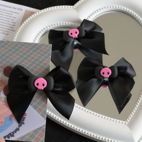 Creep It Cute Hair Bows — Three views of black skull hair bows arranged around a heart mirror.