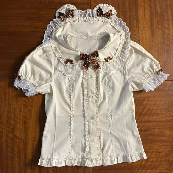 The Darling Honey Bear Blouse in apricot laid flat showing lace trim, bear-shape ears on the collar, and brown dotted bows.