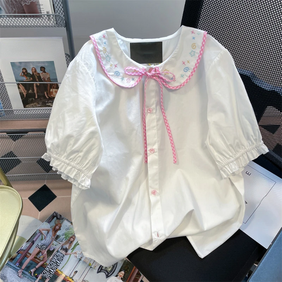 Front flat lay of the Doodle Darling Collar Blouse in white with pastel embroidered collar, pink gingham trim, and puff sleeves