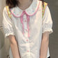 Doodle Darling Collar Blouse worn in a standing front view with pink buttons and ribbon tie visible