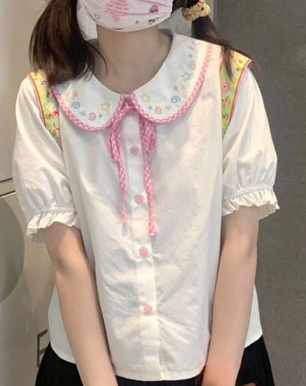 Doodle Darling Collar Blouse worn in a standing front view with pink buttons and ribbon tie visible