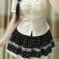 Close front view of a model wearing the Dotted Doll Lace Skort, highlighting its polka dots and white lace-trimmed tiers.